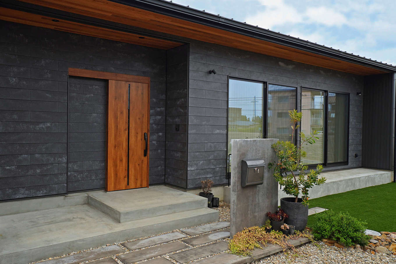 Select工房【デザイン住宅、間取り、平屋】セメントや石のような素材感の外壁材、SOLIDを使ったスタイリッシュな平屋。ガルバリウム鋼板と軒天のレッドシダー材という異素材を組み合わせることでより印象的な外観デザインとなっている