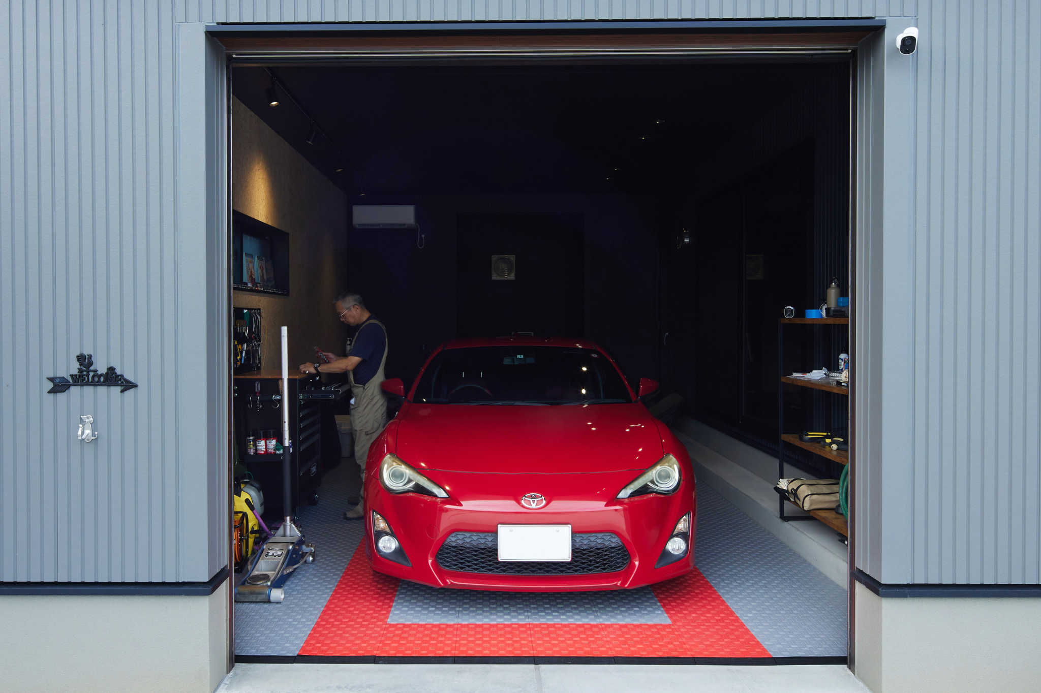 トヨタウッドユーホーム　群馬｜趣味の車を思う存分楽しめるインナーガレージ。アクセントで壁の一面に合板材を使用し、ヴィンテージな雰囲気を演出。快適に作業ができるようエアコンも完備している。
