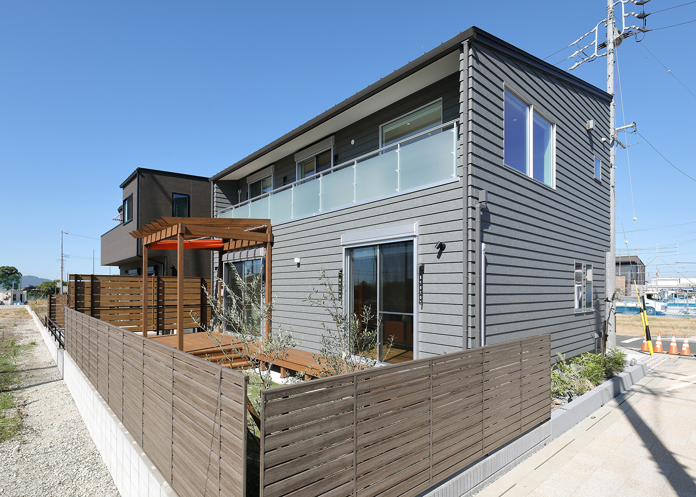 丸昇彦坂建設【デザイン住宅、趣味、間取り】ウッドデッキとパーゴラのある庭側の外観。パーゴラでは植物を育てたり、お家アウトドアを楽しんだりと、庭での楽しみが倍増する