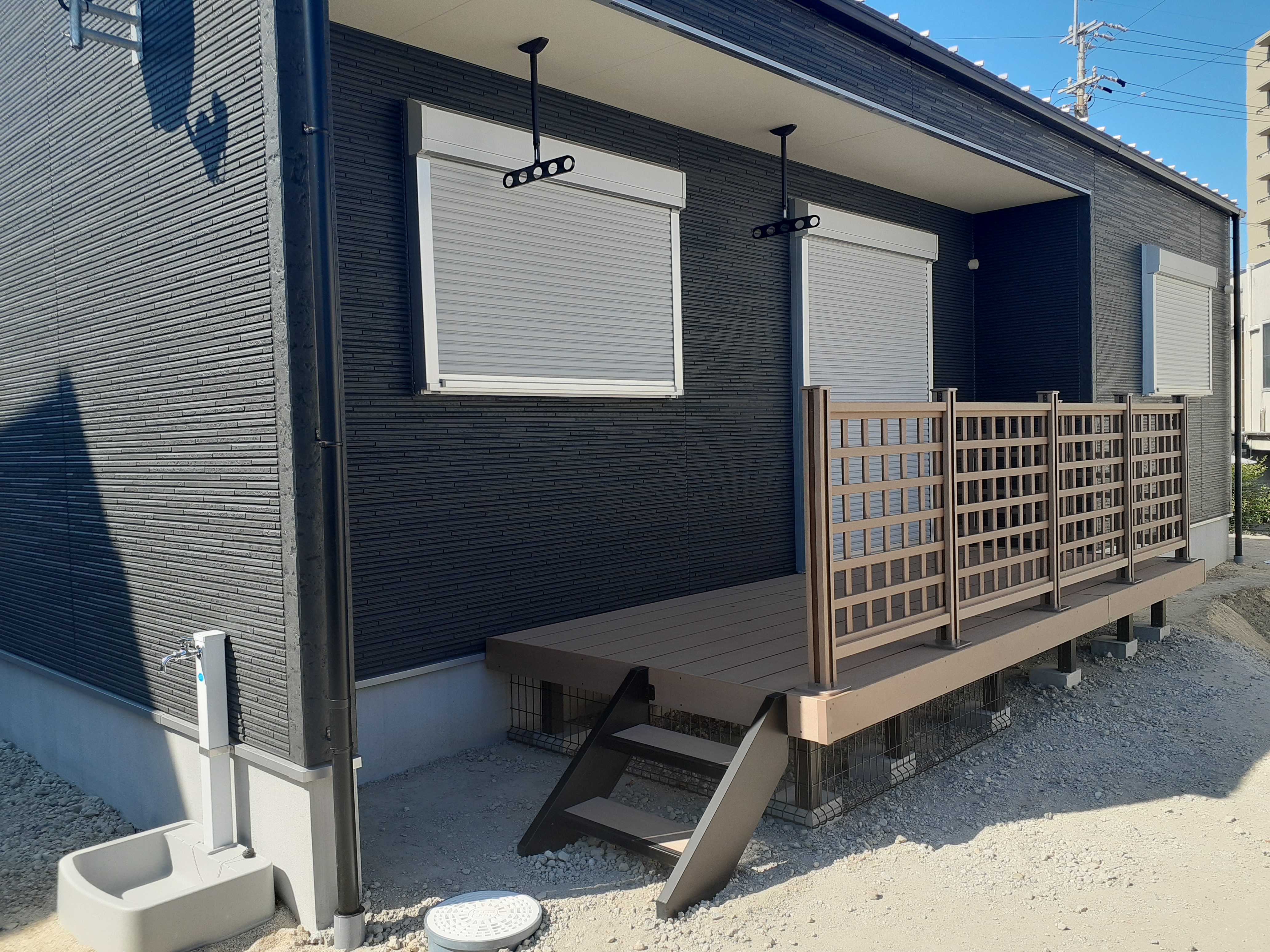 沢田建設｜家の外壁に沿って作られたウッドデッキ。シンプルなデザインが特徴で、手すりのフェンスがプライバシーを守りながらも開放感を演出している。