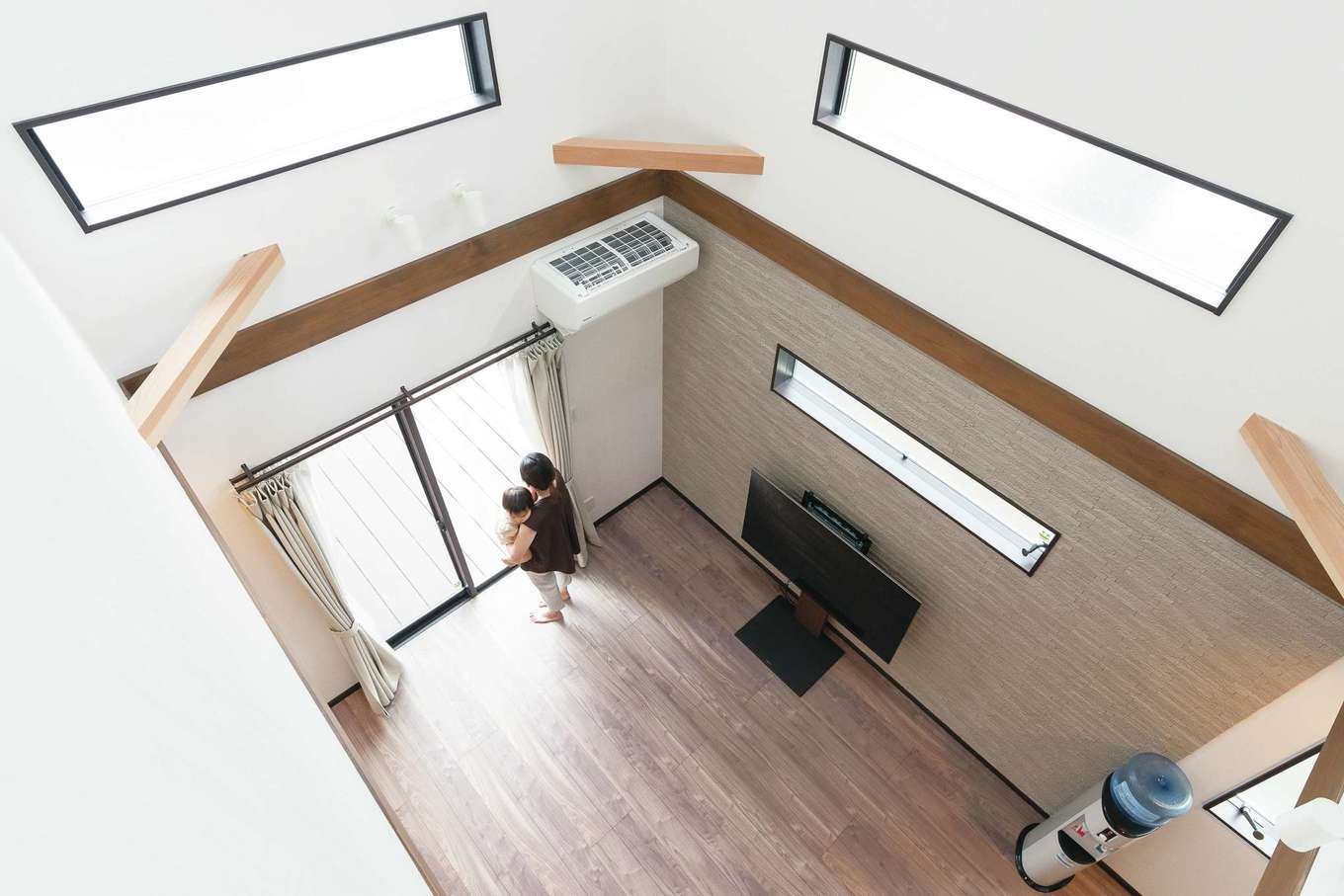 三和建設【デザイン住宅、子育て、間取り】リビング上部は大きな吹き抜け。縦方向の大空間が非日常気分をもたらしてくれる。トップライトとフィックス窓を設けているので、日中の太陽光を効果的に取り込む