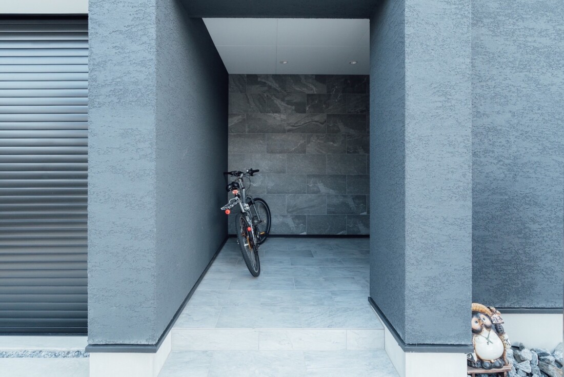 チェックハウス｜コンパクトなバイクガレージ。保護された空間内にはバイクが収納され、シンプルかつ実用的なデザインが特徴