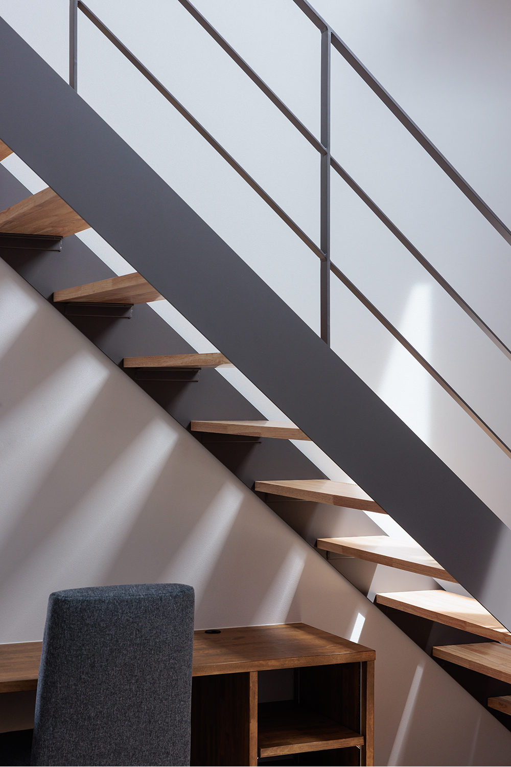 tact design firm【デザイン住宅、子育て、間取り】木製の段と金属製の手すりが調和するスケルトン階段。モダンなデザインが空間を引き立てる