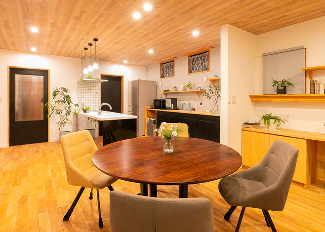 木の温もりが感じられるダイニングスペース。丸テーブルとカラフルなチェアが居心地良い空間を演出している。