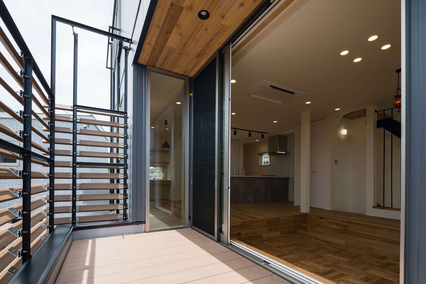 tact design firm【デザイン住宅、間取り、スキップフロア】リビングの大開口を開けると、オープンエアのバルコニーへとつながる。格子で視線を遮りつつ、BBQやティータイムを楽しんだり、愛犬と遊んだり、アウトドアリビングとして使える
