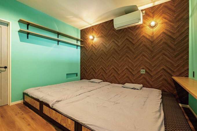 寝室は濃いブラウンで落ち着きをプラス。書きもの用のカウンターやベッドの高さに合わせたコンセントニッチも要望した。左手のウォークインは利便性に加え、ショップのような雰囲気も魅力