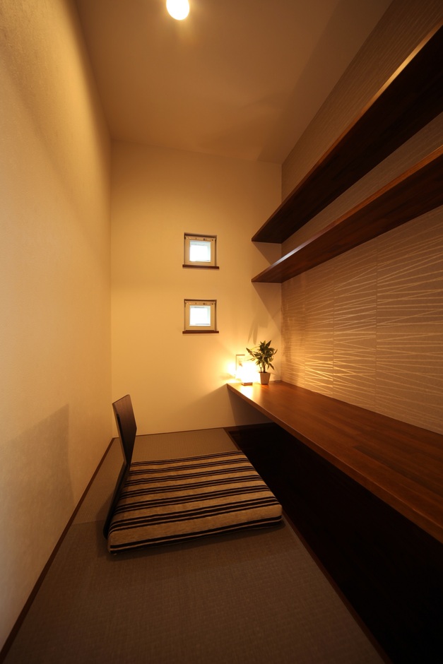 コンパクトながら機能的なスタディスペース。壁際のカウンターとシンプルなインテリアが、落ち着いた学びの環境を提供する。