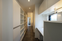 パントリーには広い棚が備えられ、食品やキッチン用品を整理整頓できる。窓から明るい光が差し込み、快適な収納スペースを提供。