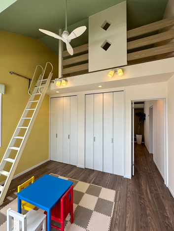 ロフト付きで空間を有効活用した子ども部屋。明るい色使いの壁とカラフルな家具が楽しい雰囲気を演出している。