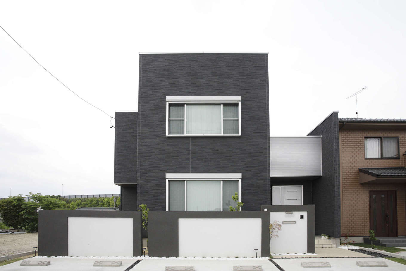 吉川住建【1000万円台、デザイン住宅、建築家】1階と2階の窓の高さ・幅を合わせ、ツートンのカラーリングもスタイリッシュな外観デザイン。タテ・ヨコのラインも美しい。エクステリアも同社の設計・施工