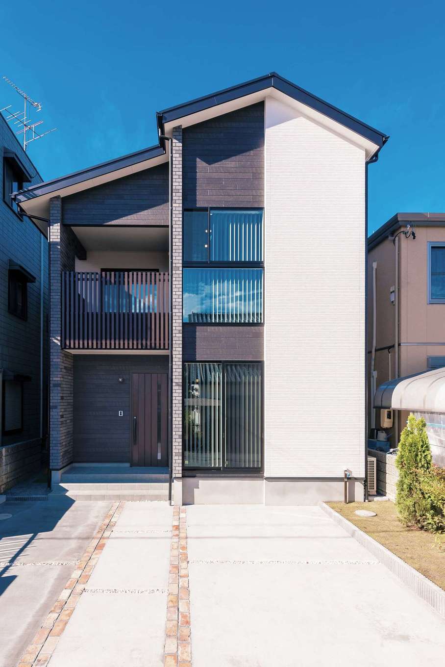 三和建設【省エネ、間取り、スキップフロア】白とチャコールブラウンでスマート感を強調した外観のデザイン。アクセントに用いたレンガは室内にも。インナーバルコニーの格子でプライバシーにも配慮