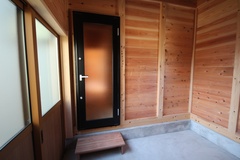 自然素材が魅力の土間空間。高い天井と明るい外光が開放的な雰囲気を演出し、多目的に使える自由なスペース