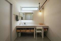 水回りのスペースにもゆとりを確保したのも夫妻のこだわり。造作の洗面台は、家族みんなで支度ができるようにカウンターを広くした。間接照明やシーリングでホテルライクな雰囲気をプラス