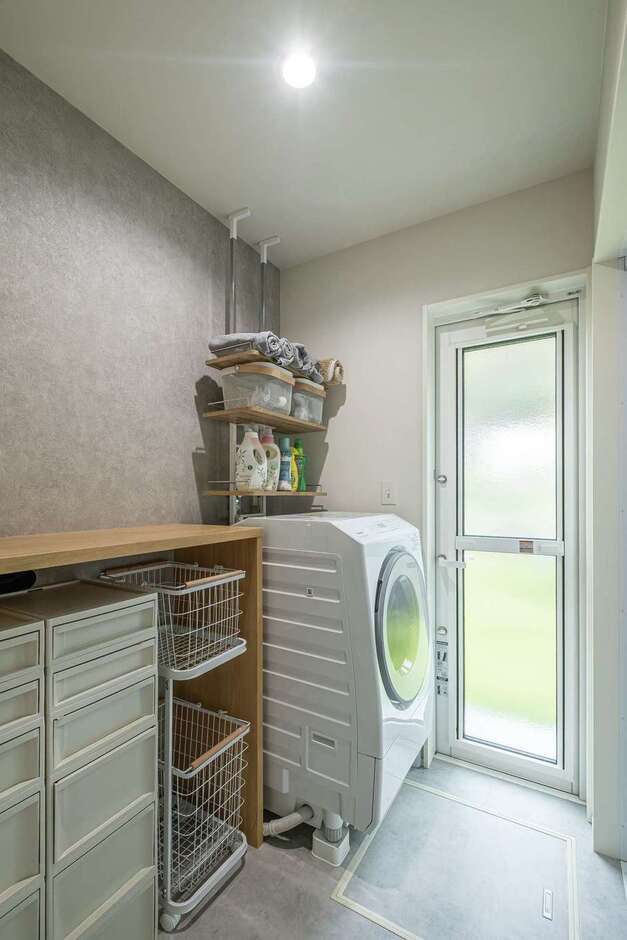 脱衣所兼ランドリールーム。造作カウンターの下は、必要に応じたアレンジが可能なオープン収納に