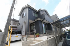 現代的なデザインの住宅。ダークカラーの外壁が特徴的で、洗練されたスタイルを演出している。