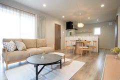 明るく開放的なLDK。ソファとダイニングセットが配置され、家族団らんの時間を楽しめるスペースが広がっている。