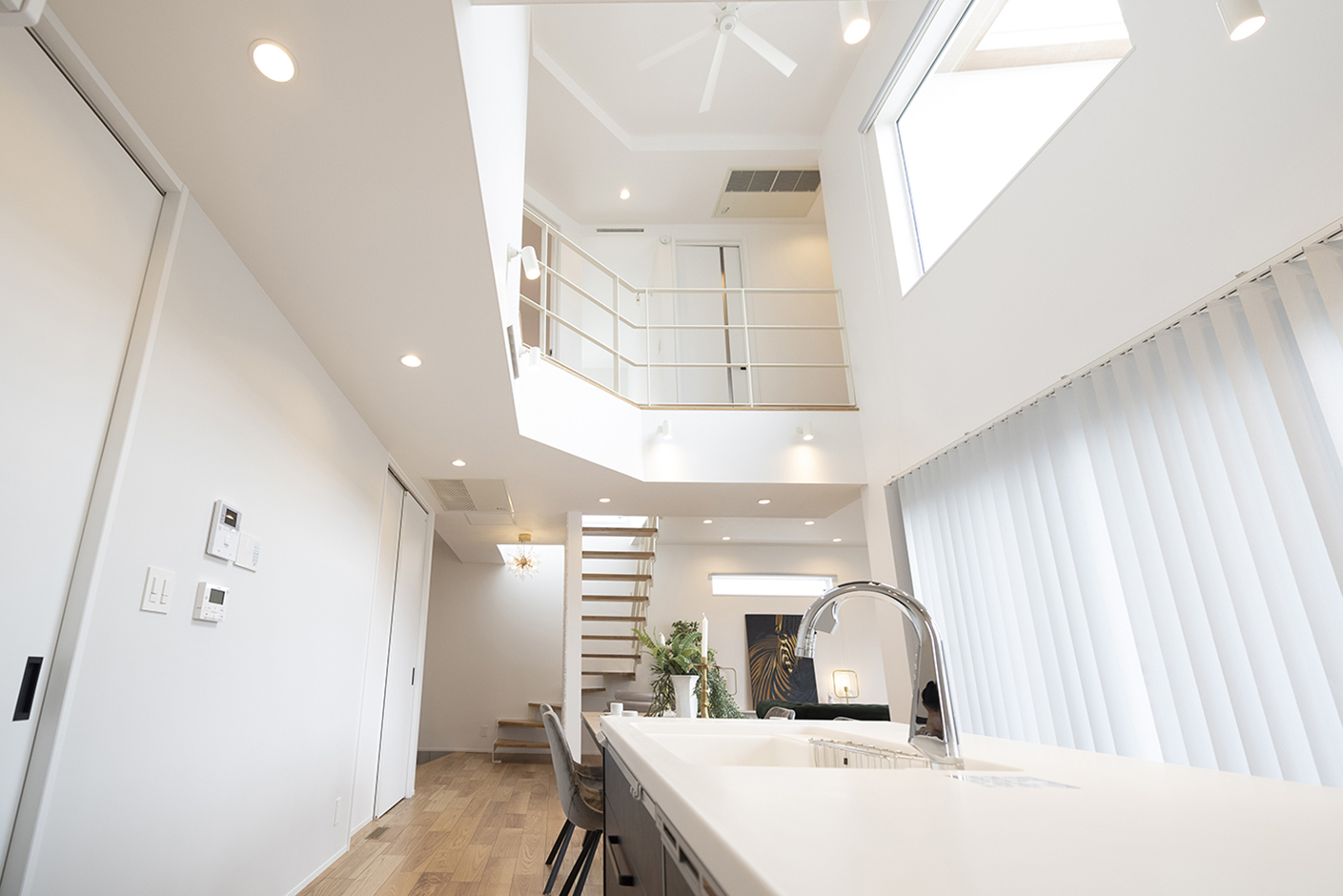 OWN RESORT HOME（オウンリゾートホーム）【デザイン住宅、子育て、間取り】ダイナミックな吹抜けのLDK。天井まで届くハイドアを採用し、空間を白で統一したことで、より明るく、広く感じられる