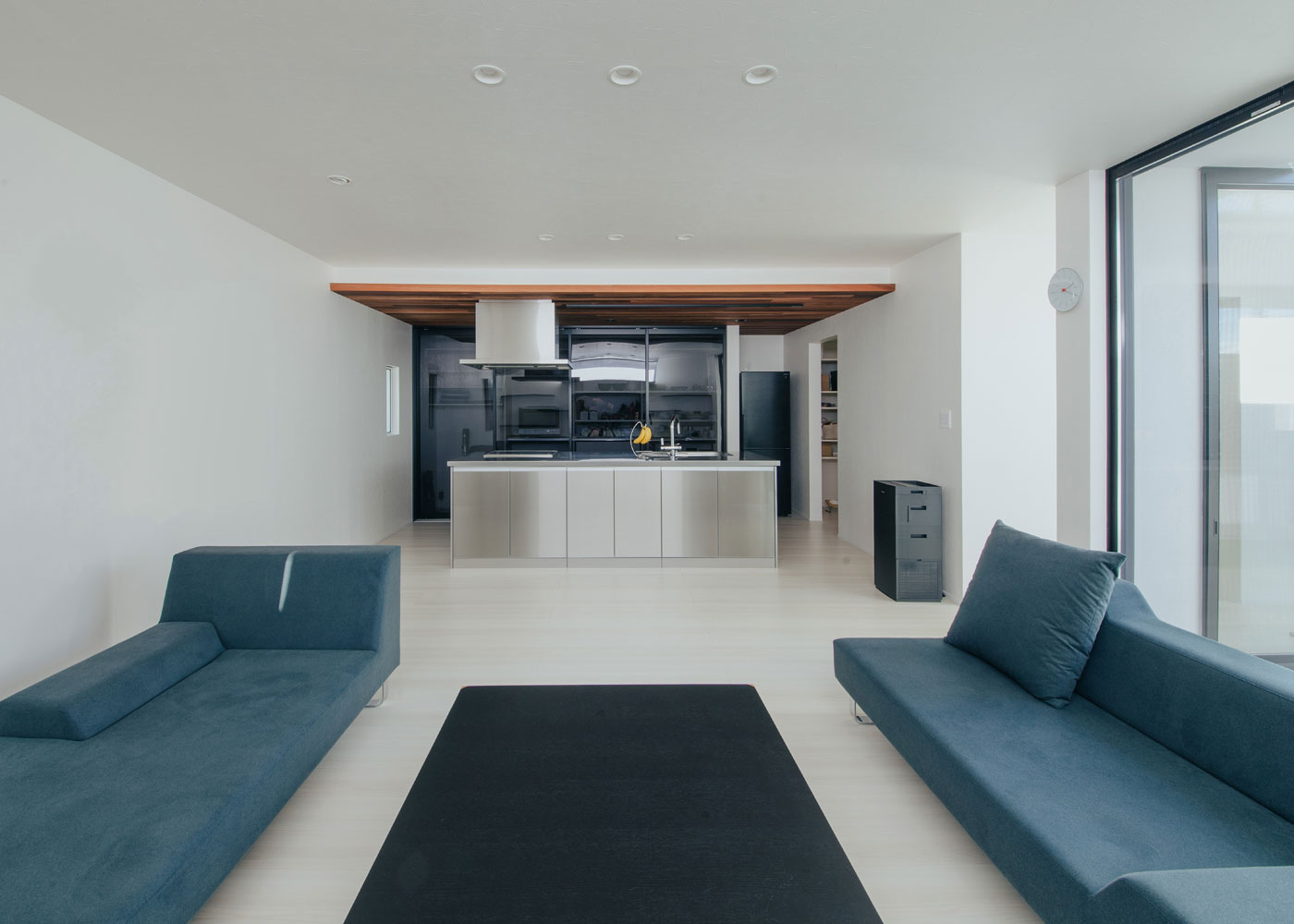 ハウスコネクト【デザイン住宅、ペット、平屋】中庭からやさしい光が差し込むLDK。ローバックのソファ＆ローテーブルを置いたことで圧迫感がなく、空間がより広く感じられる。オールステンレスのアイランドキッチンもよく似合う