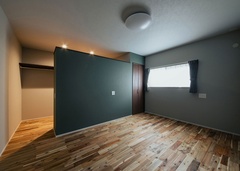 家族の居室は、部屋ごとに床や壁色を変えてコーディネート。こちらは濃いグリーンのクロスを採用して落ち着いた印象に仕上げた