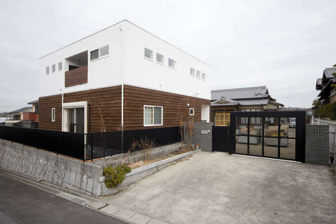 漆喰×無垢の鎧張りで仕上げた外観。道路側からは箱型に見えるが、実際は台形のカタチをしている