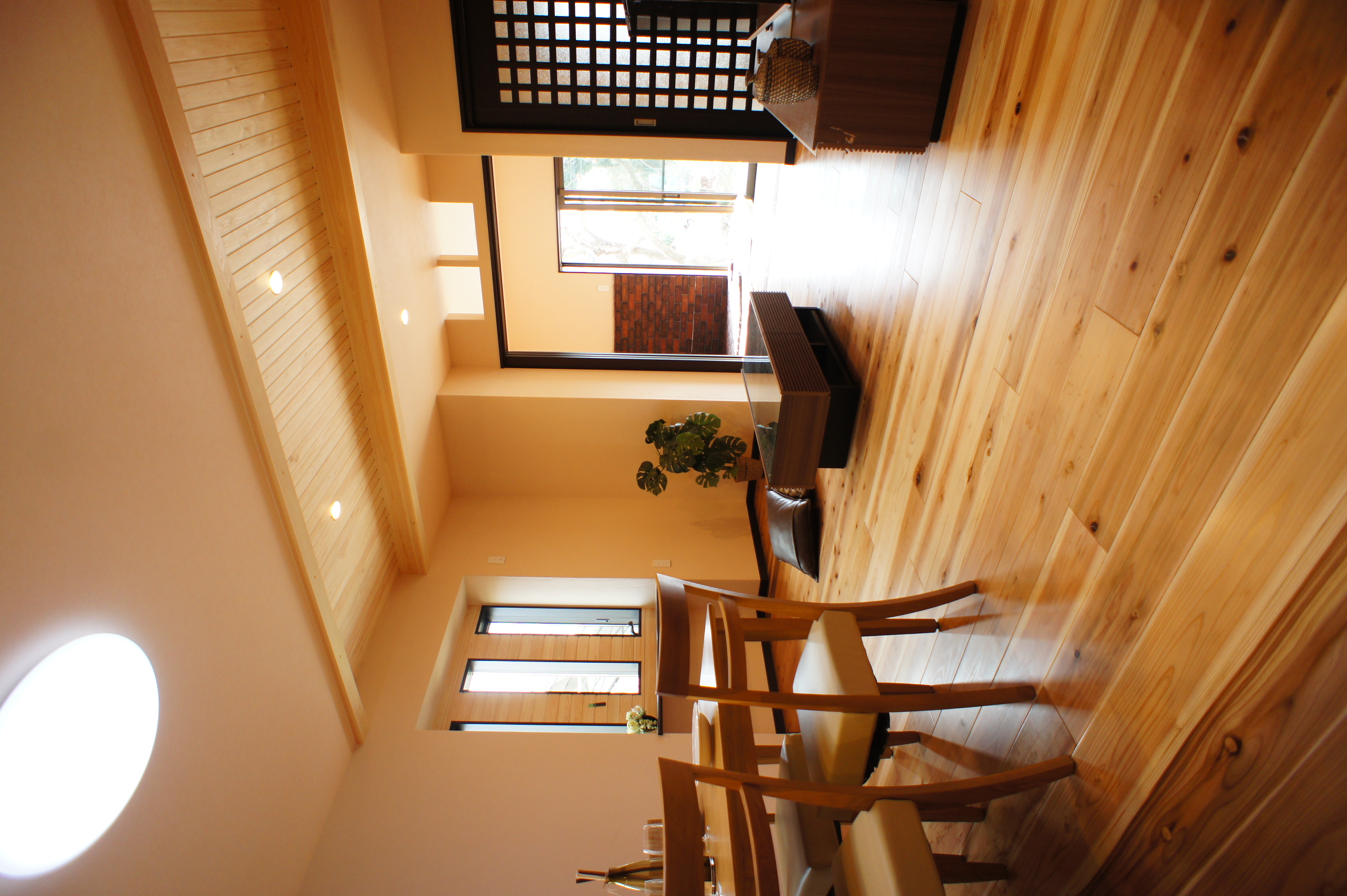 小野田産業～designers house project～｜光が差し込む温かみのあるLDK。ナチュラルな木目の床が自然を感じさせ、落ち着いた雰囲気を演出している。広々とした空間にはダイニングセットとソファが配置されており、ゆったりとした時間を楽しめる。