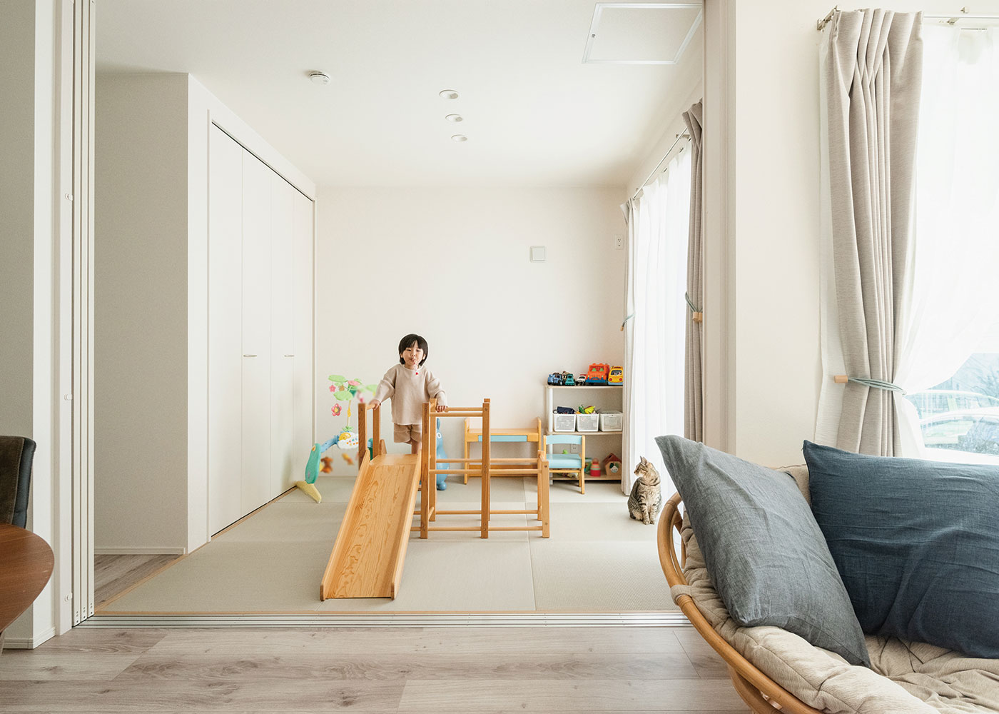 HAPPY HOUSE（山田工務店）【デザイン住宅、間取り、平屋】遊び場やお昼寝にピッタリの畳スペースは、キッチンから目が届くので安心。LDKとテイストをそろえることで、普段は開いて一体感を演出。実家の両親が訪れた際には間仕切りを閉じ、客間として機能
