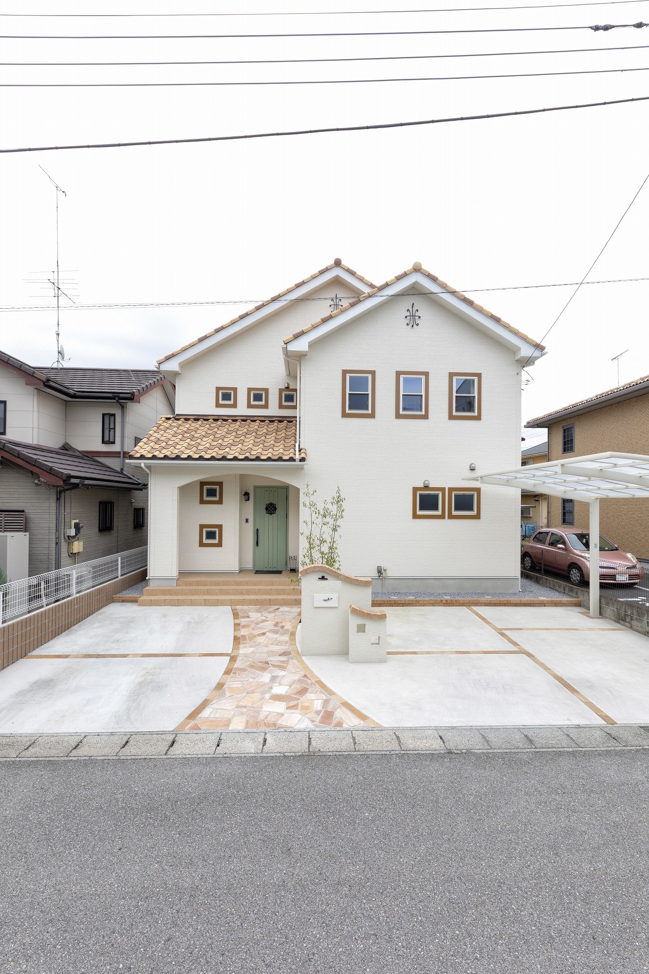 アヴィエスホーム｜白を基調としたシンプルで美しい二階建ての住宅。機能的な駐車スペースと整備されたアプローチが魅力