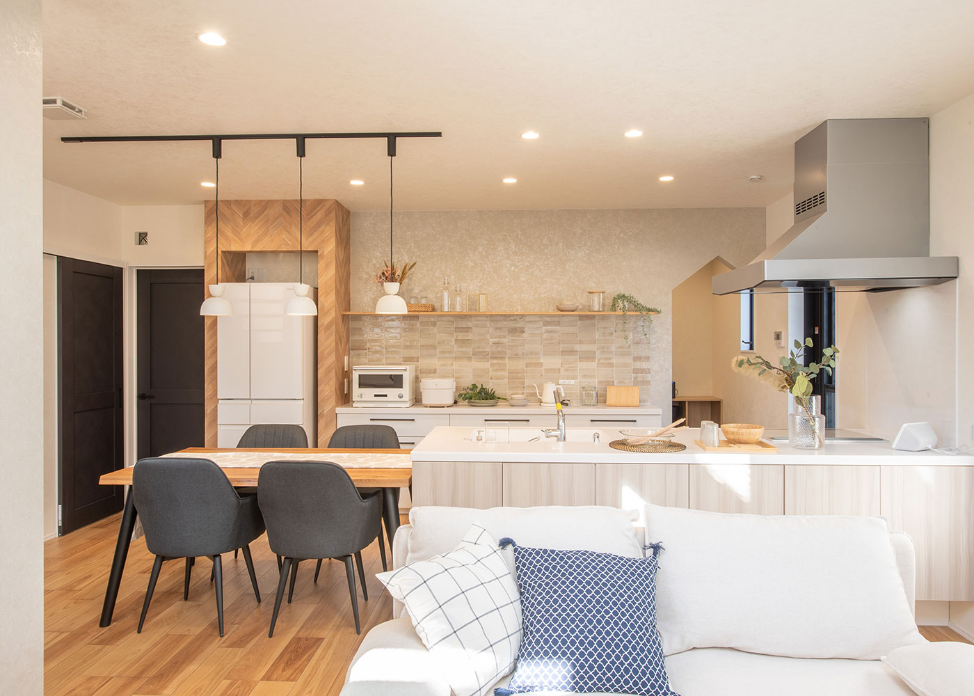 小野田産業～designers house project～【静岡市清水区青葉町6ｰ18・モデルハウス】オープンタイプのキッチンと、横並びで使いやすいダイニング。キッチンには25年間保存できるおいしい非常食を備えている。カーテンの開閉、エアコンや照明などはスマートスピーカーにより音声で操作できる