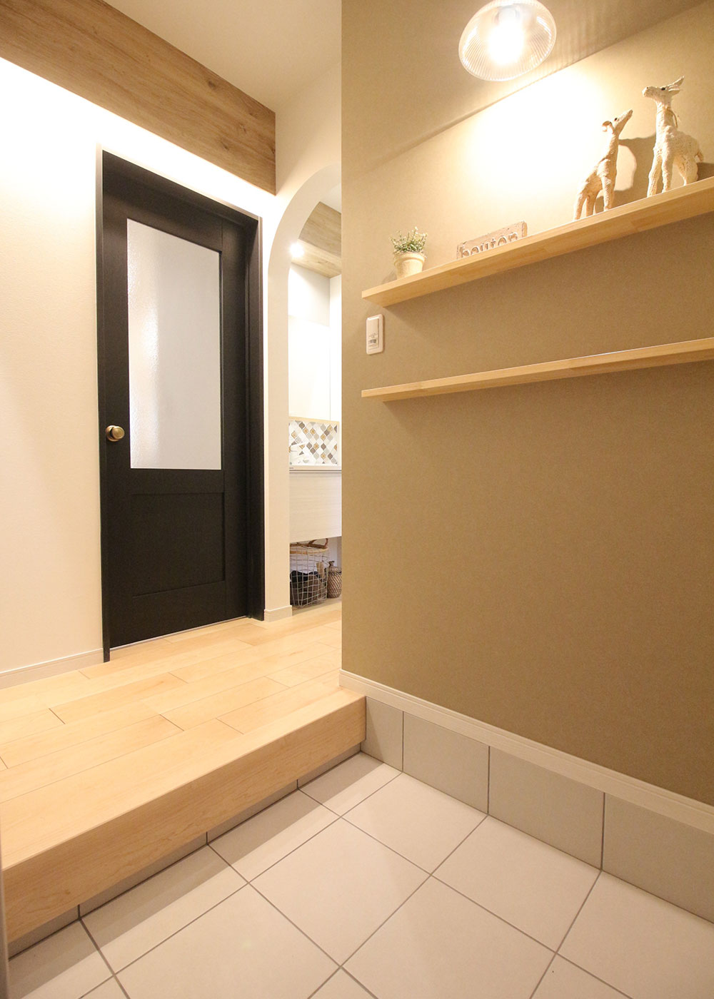 小野田産業～designers house project～【1000万円台、デザイン住宅、子育て】さりげないディスプレイを照明がおしゃれに演出する玄関。帰宅時には、やさしい色使いとあたたかな光にホッとする