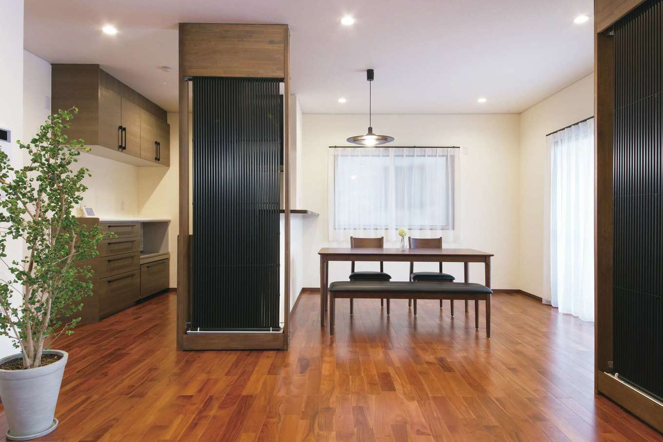 エコハウジング【デザイン住宅、自然素材、省エネ】高級感ただよう床は無垢のチーク。「クール暖」がキッチンを隠す格子代わりにもなっている