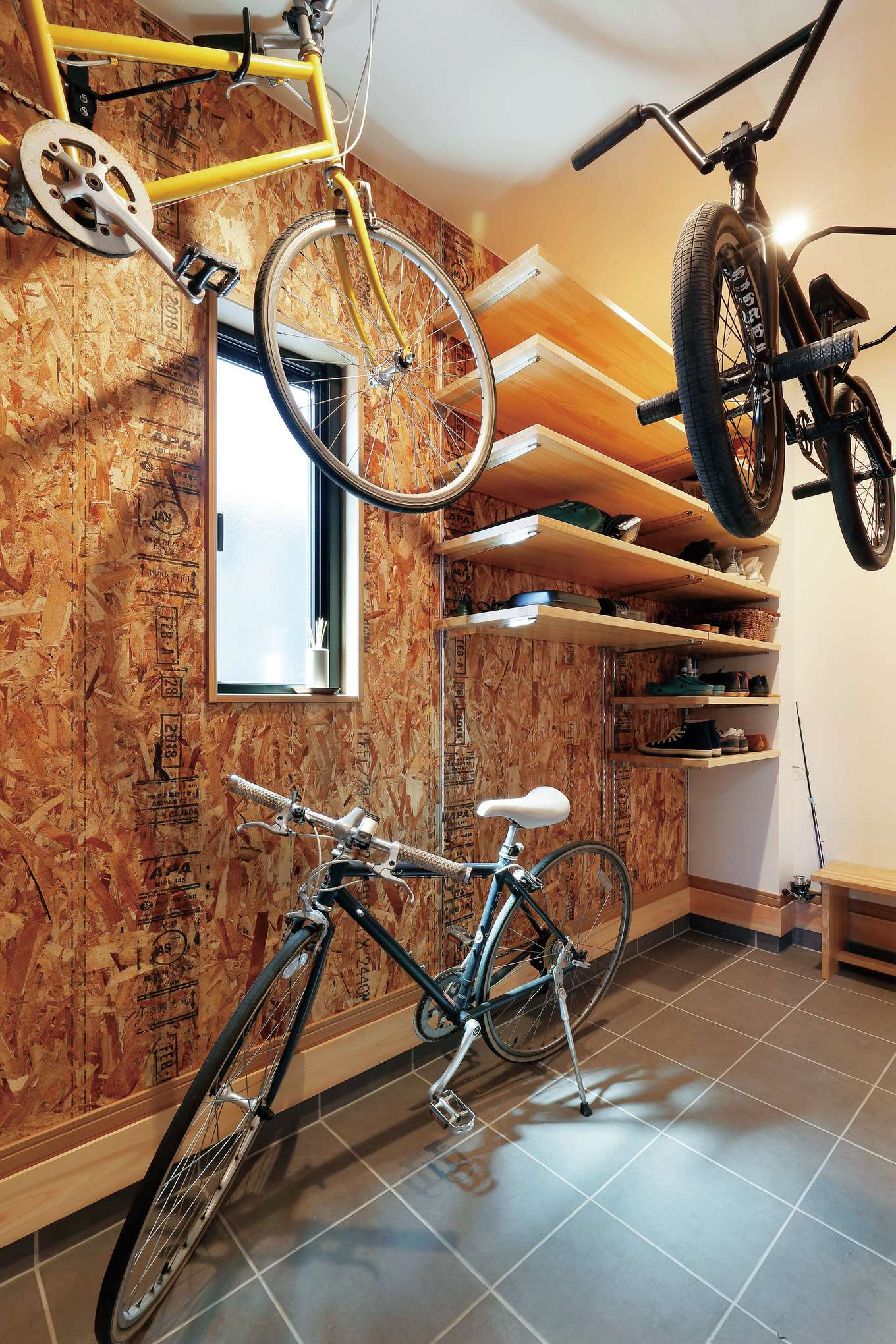 フジモクの家（富士木材）【デザイン住宅、収納力、自然素材】土間仕上げの玄関ホール。ご主人のBMXと奥さまの自転車を保管できる広さの収納を確保。OSB合板でワイルドにしつらえた