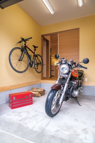 ビルトインガレージには、ご主人のバイクが2台＋自転車も余裕で入る。雨の日も ここで整備ができるので便利