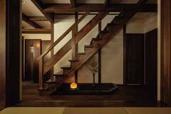 「腕のいい大工さん、気が利く監督さんでありがたかった」とご主人。階段下には玉砂利が敷かれた箱庭。ほどよい和の風情が空間になじむ