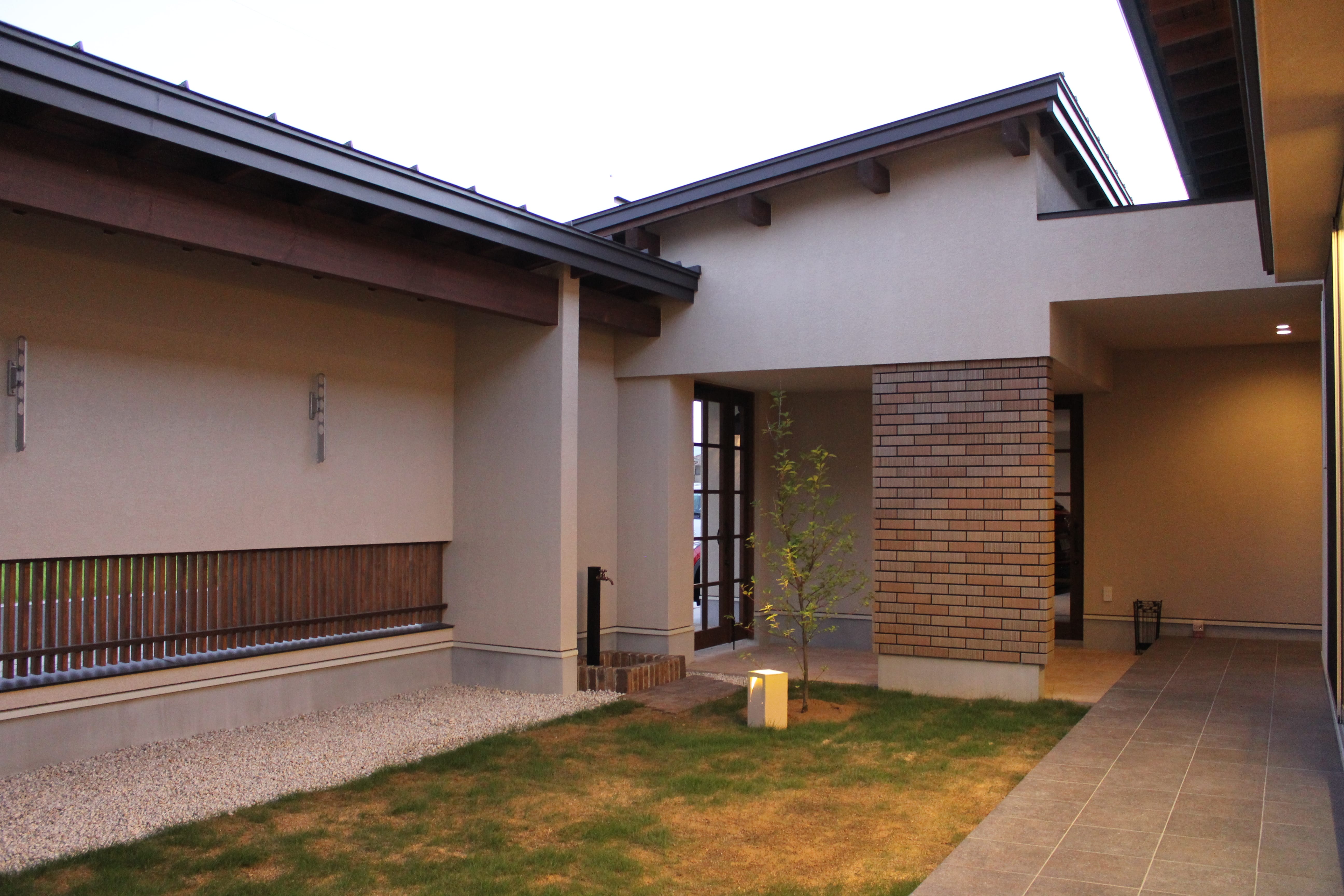 安田住宅｜安田建築設計室｜シンプルで落ち着いた雰囲気の中庭。自然光が入り、心地よい空間を提供する。煉瓦のアクセントが印象的なデザインである。