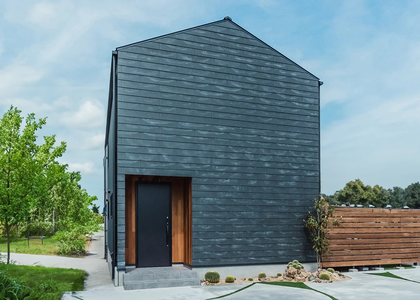 オレンジハウス【静岡市葵区沓谷5-9-14・モデルハウス】【HYGGE】西向きの玄関側には窓を設けず、西陽を入れずに快適に暮らせる外観デザインがプライバシーを守る。強靭なセメント外装材「SOLIDO」を貼った外壁は経年変化も美しい