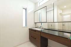 「将来子どもが大きくなったときのプライバシーに配慮して」と、脱衣室と分けた洗面室。カウンターと鏡をワイドにすることで、朝の支度が重なってもスムーズにできるように