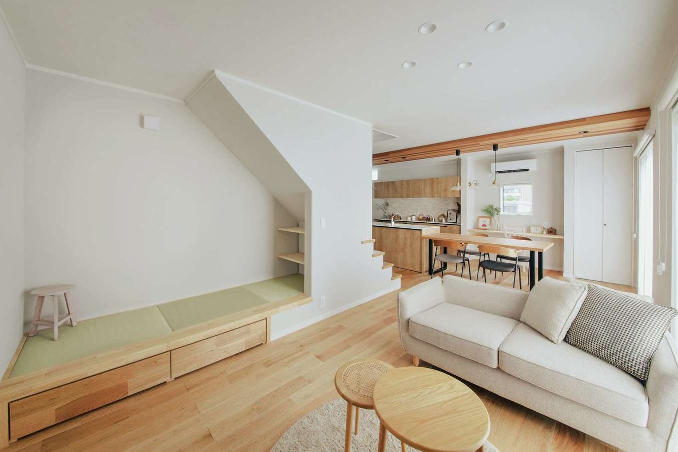 ほっと住まいる【自然素材、間取り、インテリア】無垢のクルミ材の床と、天然素材を材料にした白子塗り壁の優しい色合いが心と体を癒やすLDK。天然素材ならではの調湿効果、消臭効果も心地よく、室内はいつも快適だ。階段下スペースを活用したヌック風の畳コーナーは、ソファ代わりにも使える