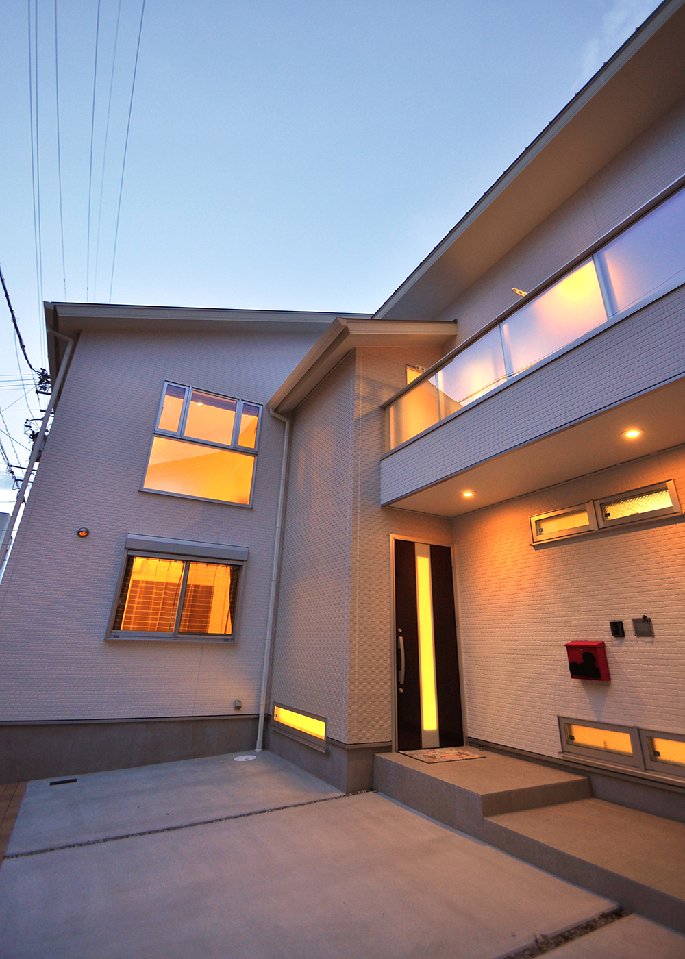 丸昇彦坂建設【デザイン住宅、間取り、インテリア】室内から零れる電球色の光が美しく、照らされた白の外観は淡いピンク味を帯び、まるでショートケーキのよう