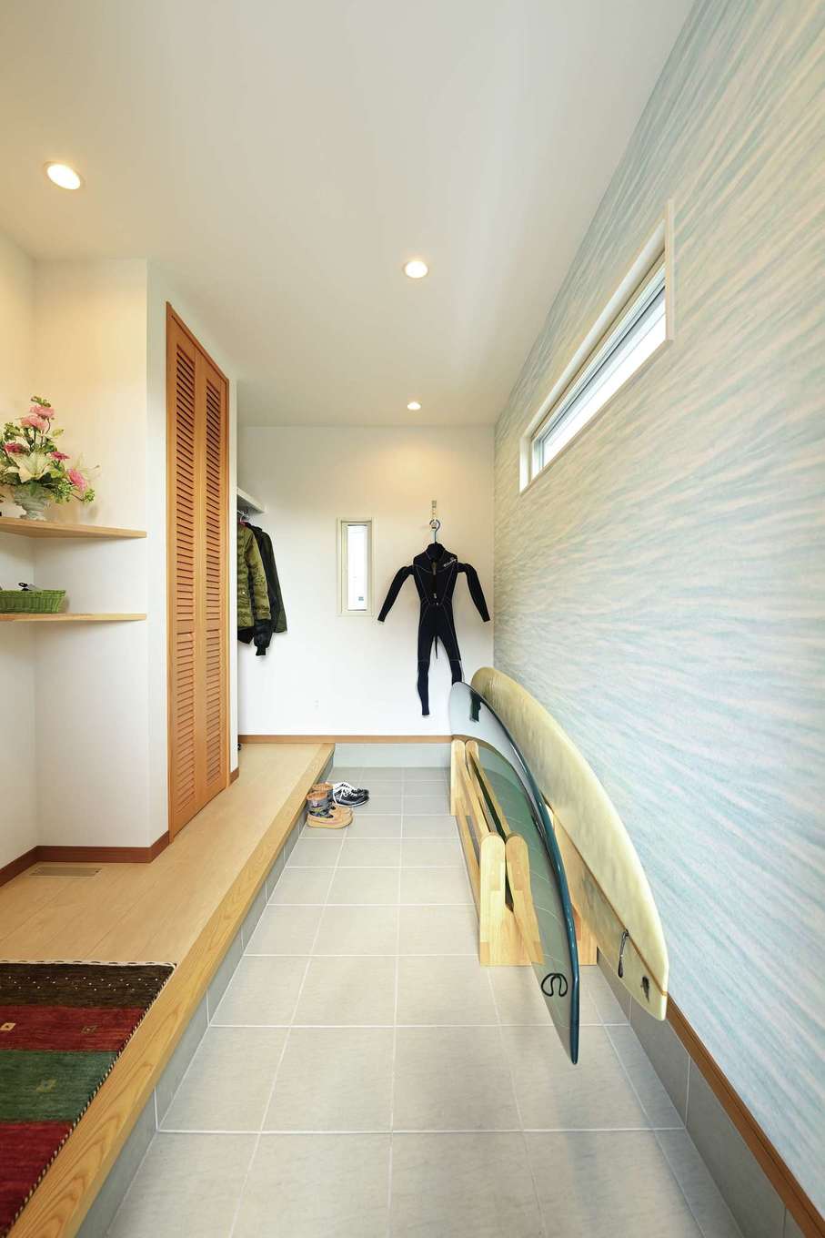 Yamaguchi Design 【デザイン住宅、夫婦で暮らす、平屋】長さ2.9mのロングボードも楽々収納できる土間玄関。水色のクロスは波をイメージ
