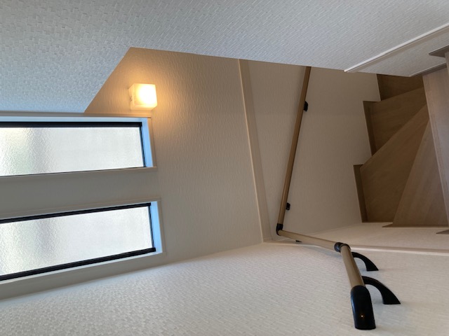 タムラ建築設計｜壁際に設置された階段。手すりもあり、安全性が考慮されている。上部の窓から自然光が入り、明るい空間を演出している。