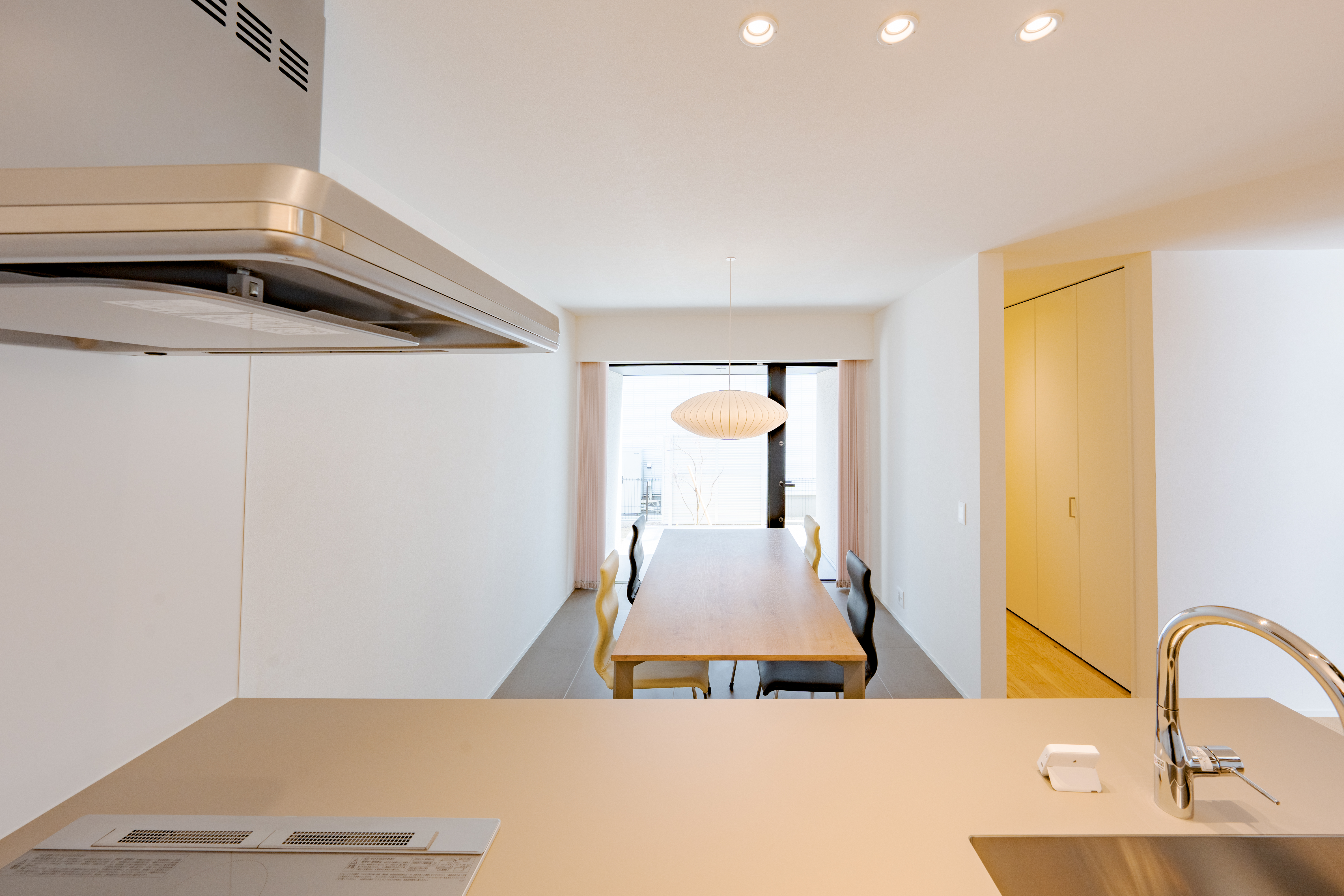 三建 大阪南支店｜キッチンからダイニングを望むオープンな空間。シンプルなデザインが特徴で、食事を楽しむ際に心地よい雰囲気を提供している。