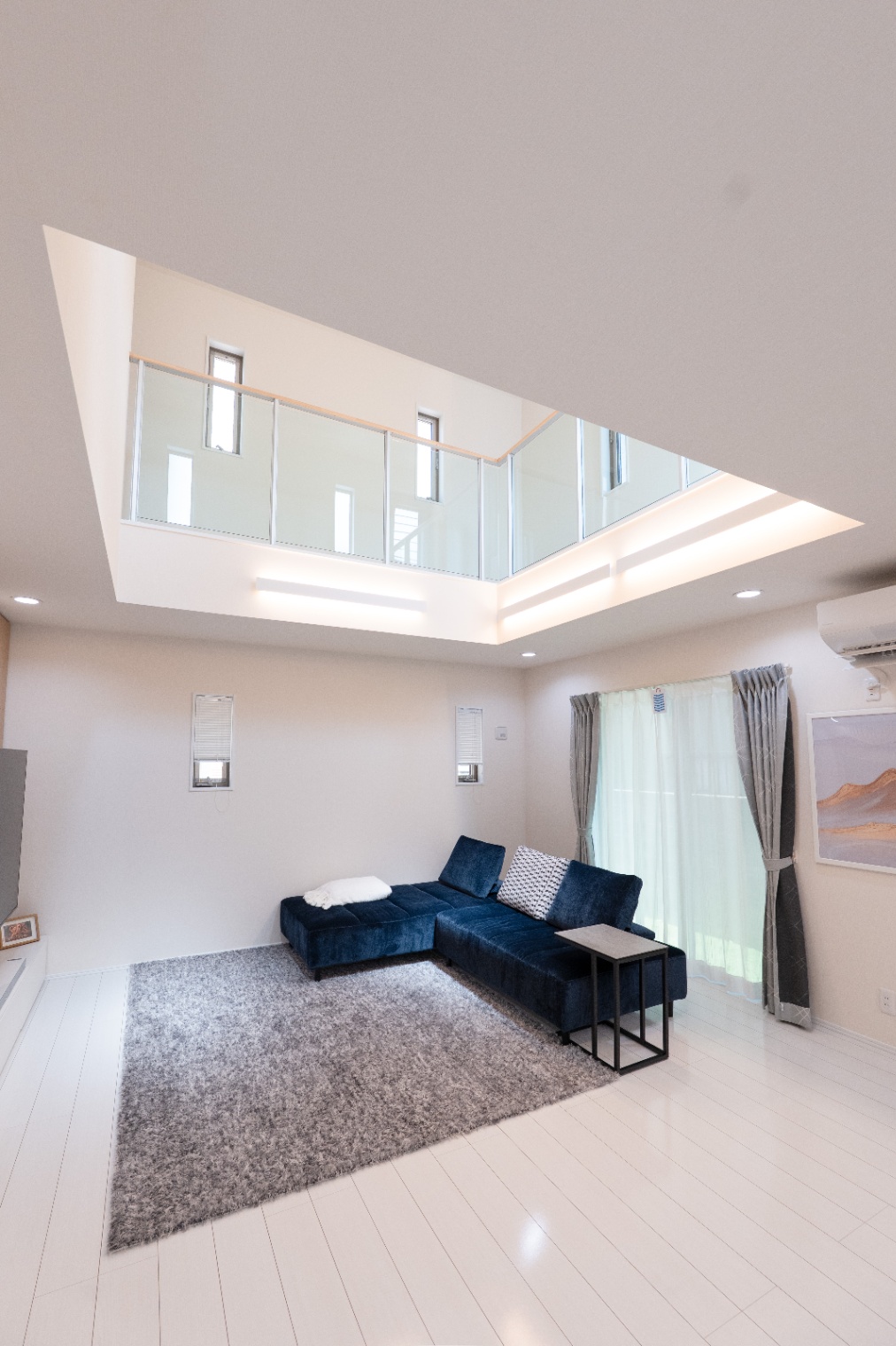 アイダ設計　｜開放感のあるLDK。吹き抜けが設けられ、光が多く入り込む空間でリラックスした時間を演出する。