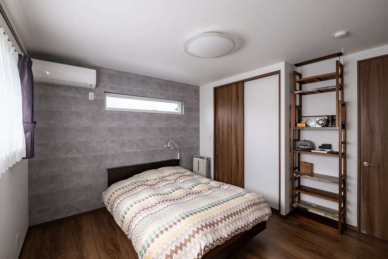 イデキョウホーム【デザイン住宅、省エネ、間取り】ハイセンスで落ち着ける雰囲気の寝室。壁の一面だけをアクセントクロスに変えて、表情に変化をつけた