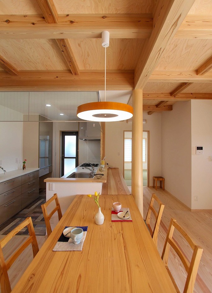 アクトホーム【自然素材、省エネ、間取り】配膳・片付けがしやすいよう、ダイニングテーブルはキッチンと横並びに配置した。キッチン奥の勝手口からは、サービスヤードに出られる。