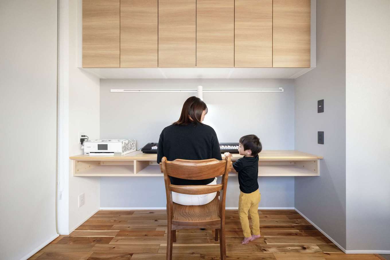 ハウスプラン（R＋house沼津・富士）【デザイン住宅、省エネ、建築家】リビングデスクは家族が思い思いに使える有能なスペース。本来キッチンの背面に付けるタイプの扉付き収納をここに採用した