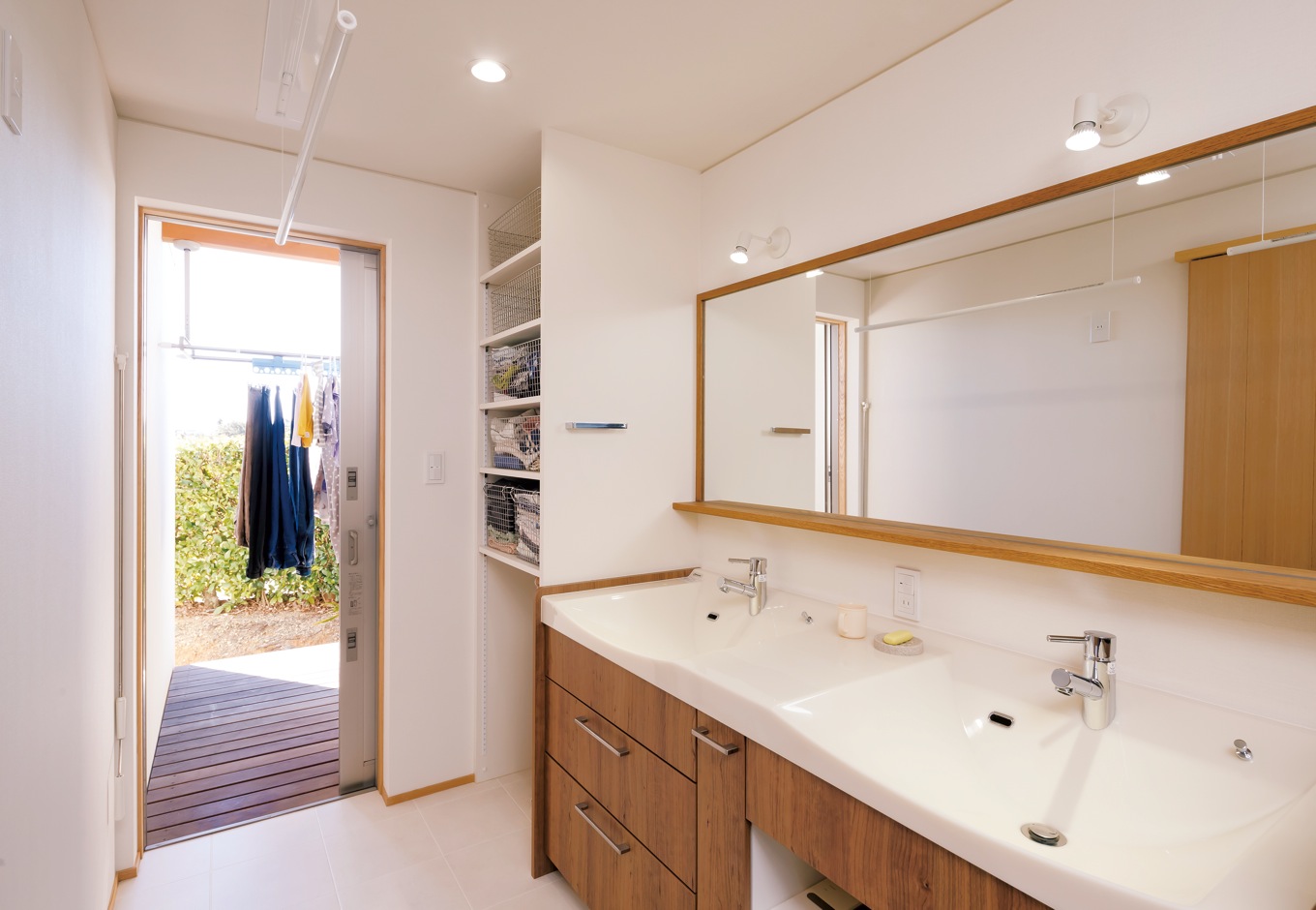 神谷綜合建設 カミヤの家【自然素材、間取り、インテリア】既製品の洗面台に合わせて、オリジナルの鏡をコーディネート。洗面・脱衣室では室内干しができる上、すぐ先に物干し場もあるので便利