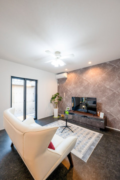 リビングエリアをカッコよく演出するタイル調のフローリングは、お手入れもラクラク。テレビ背面の壁にもシックなデザインクロスを採用し、上質な大人のくつろぎ空間に仕上げている