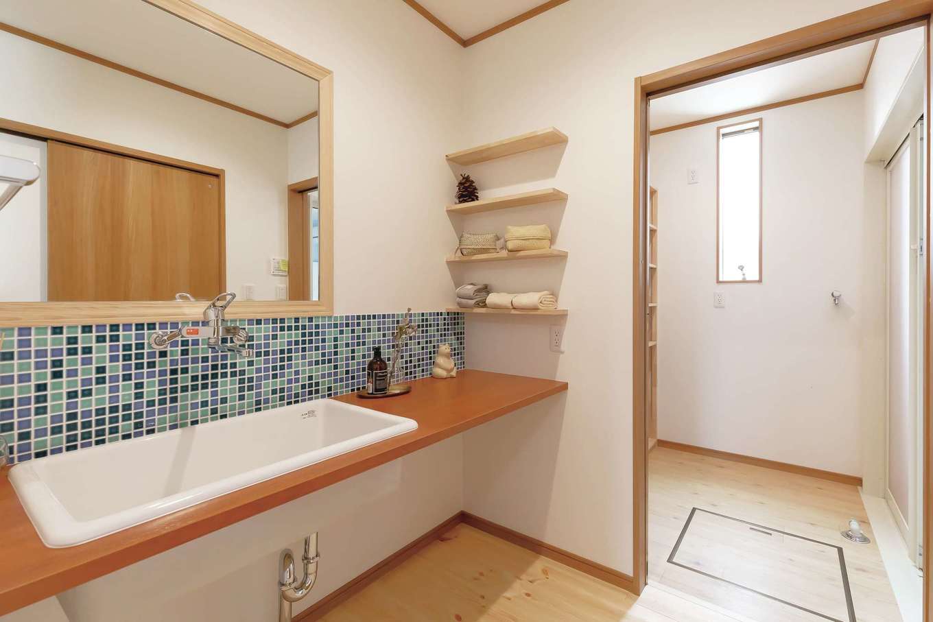 住まいるコーポレーション【デザイン住宅、自然素材、夫婦で暮らす】洗面スペースと奥の脱衣場はスペースを広々と確保。シンクも鏡もビッグサイズで使いやすさが抜群