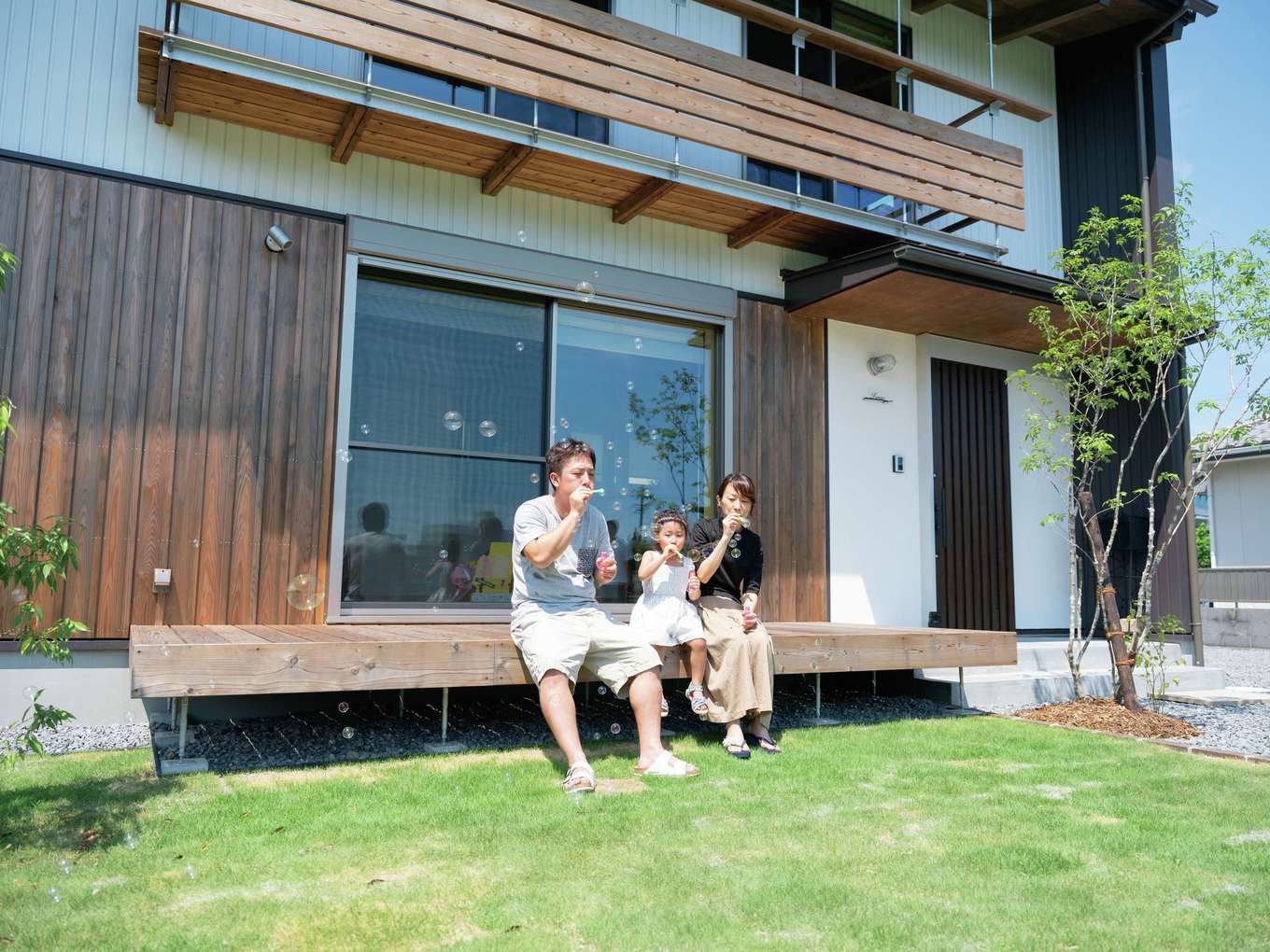 アクトホーム【子育て、自然素材、省エネ】1階のウッドデッキと2階の吊りデッキで、家でもアウトドアの開放感を楽しめる。夏の強い日差しを遮るための長く張り出した軒先も、パッシブデザインのひとつ