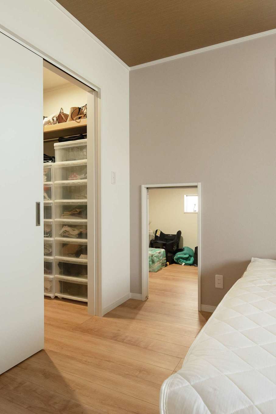 サンワ開発【デザイン住宅、収納力、間取り】寝室にはクローゼットとは別に小屋裏収納を設けた。フラットな出入り口は荷物の移動が苦にならず、季節外の布団や家電の収納に便利